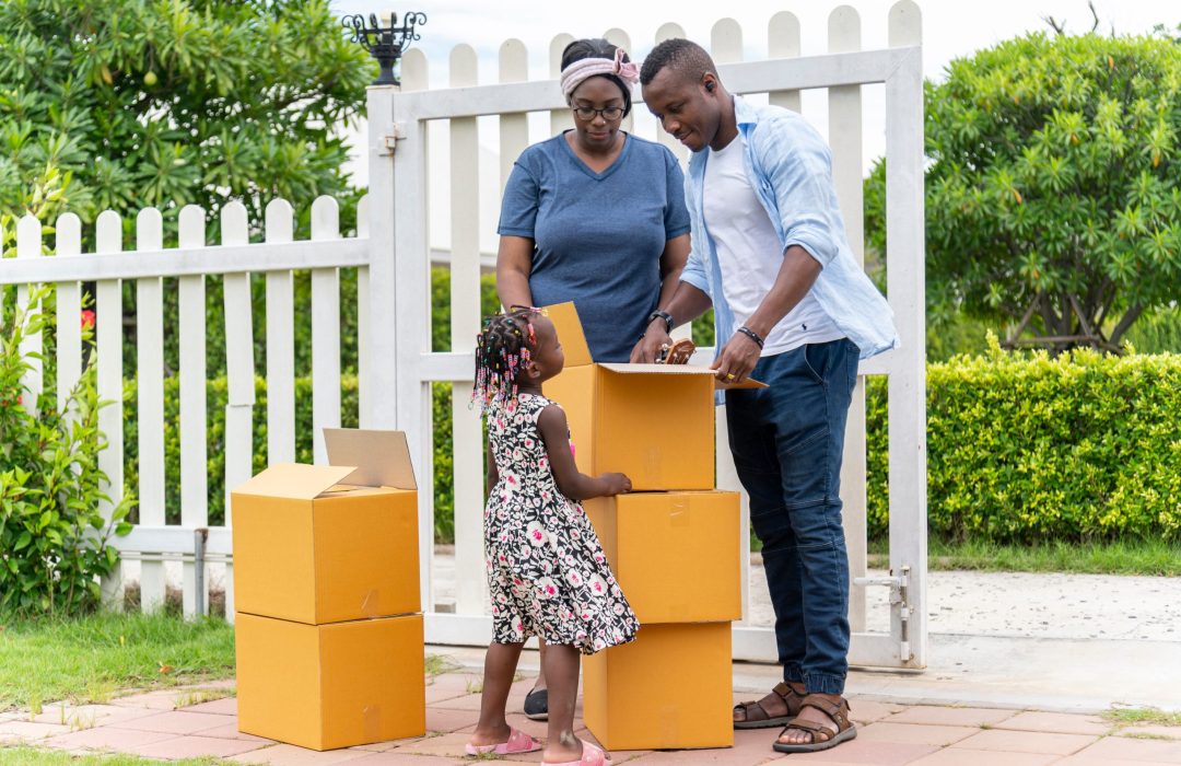 Happy African American family carry cardboard box for moving new house on moving day, Young back girl find personal belongings.